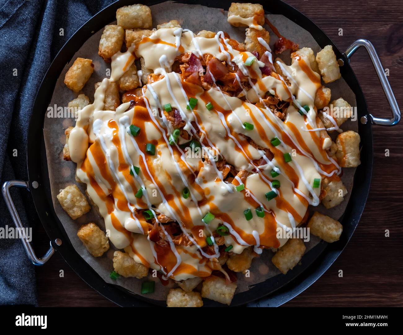 A platter of buffalo chicken tater tot nachos fresh out of the oven Stock Photo