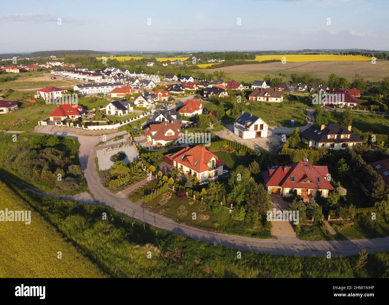 Residential neigborhood in sunset, bird eye view. Suburbs or village streets with luxury house buildings Stock Photo
