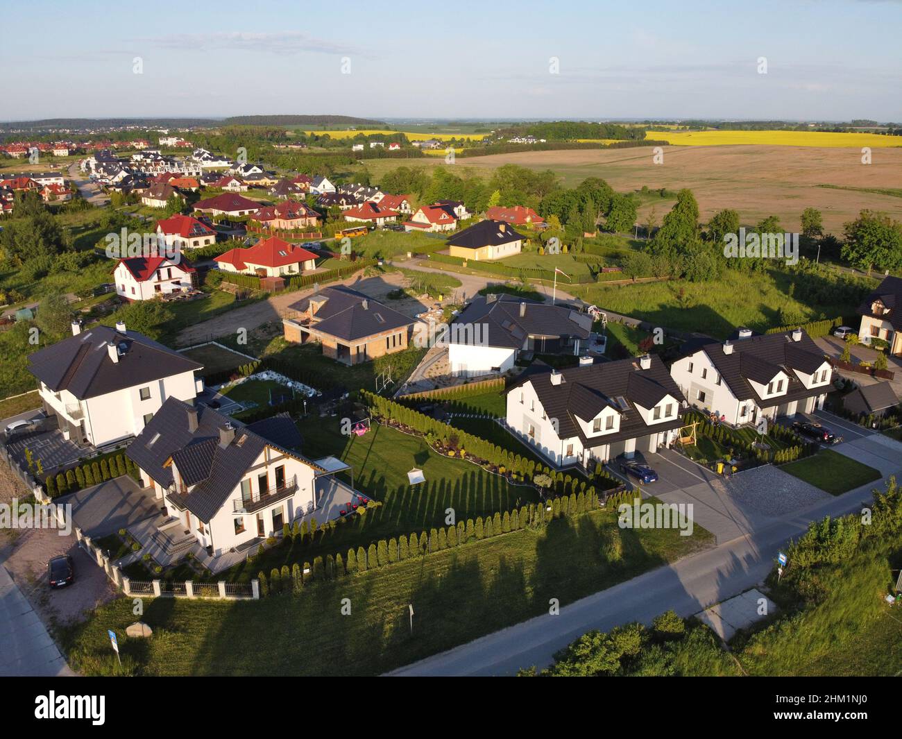 Residential neigborhood in sunset, bird eye view. Suburbs or village streets with luxury house buildings Stock Photo