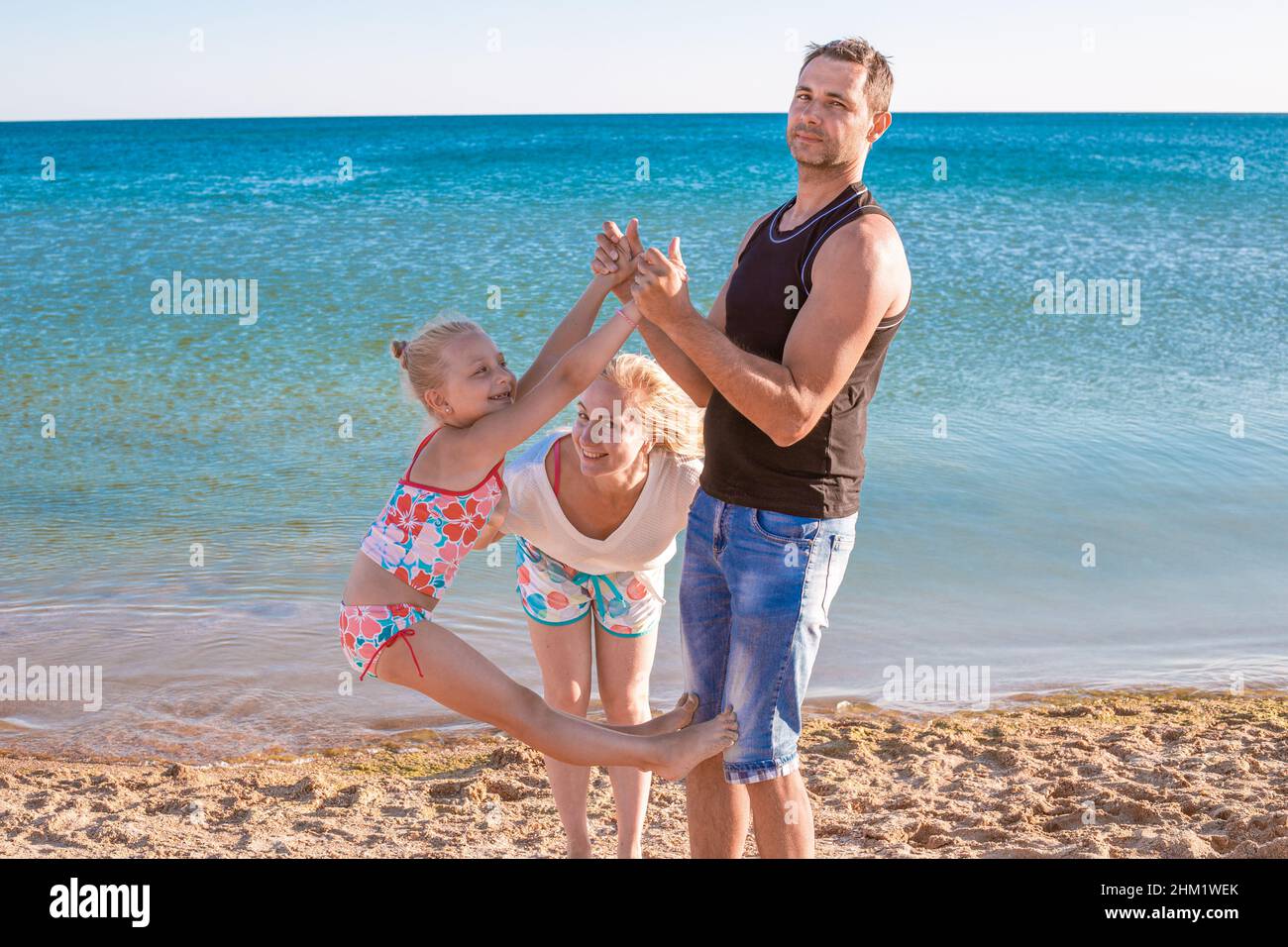Happy family at sea. Man, woman and child have fun on the seashore. Summer holidays, travel and tourism. Stock Photo