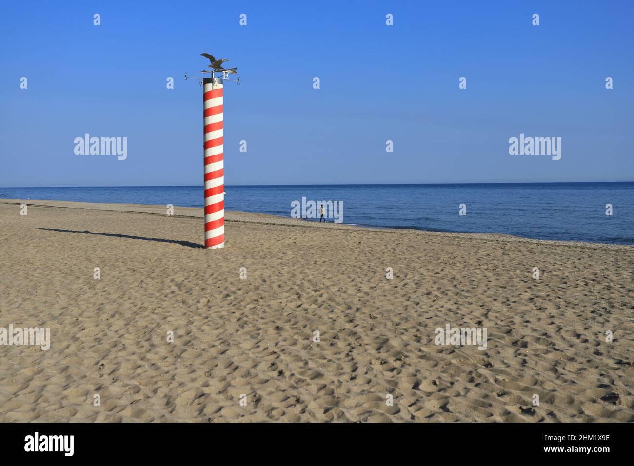 Red and white pole as symbol of the most northern point of Poland. Pole at Jastrzebia Gora beach. Stock Photo