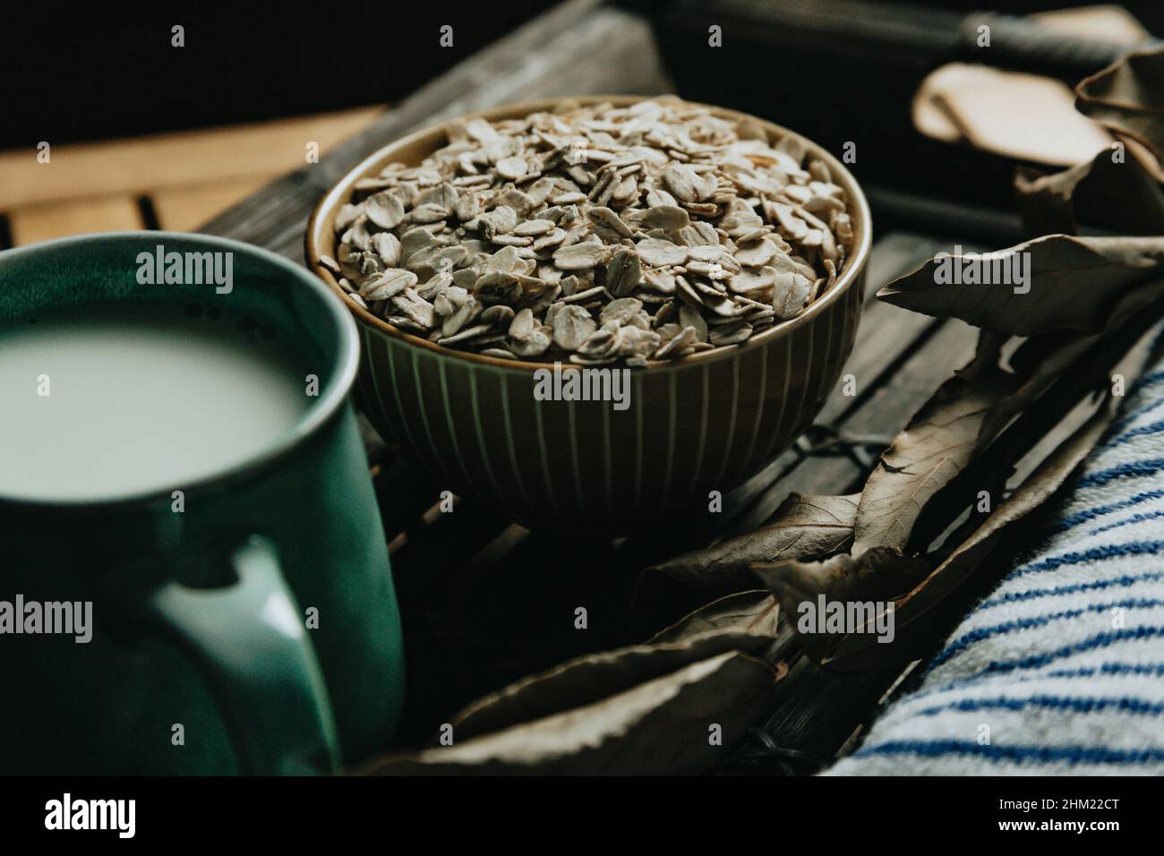 A close up of a bowl filled with oat seeds over a wooden table on moody tones Stock Photo