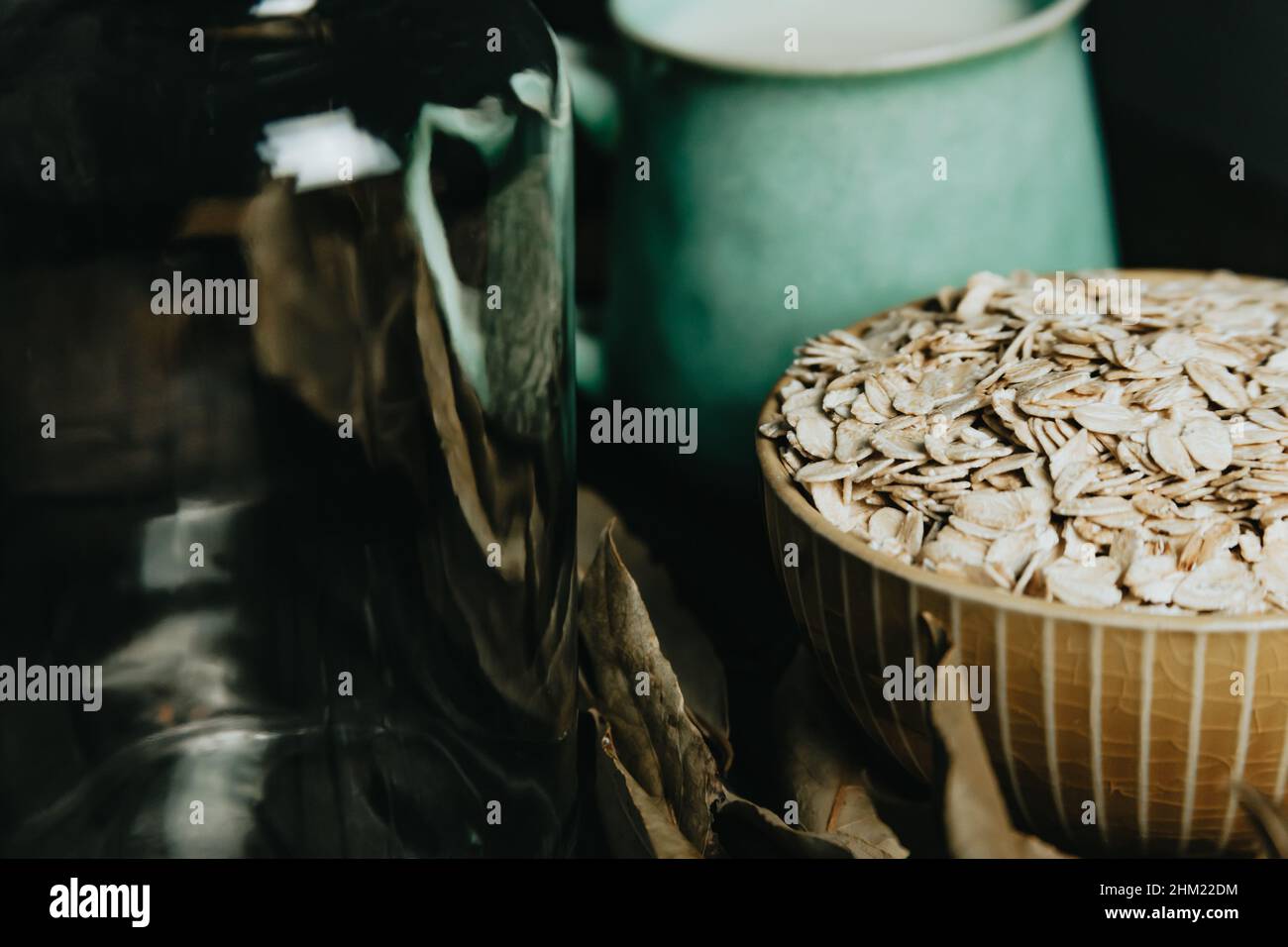 A breakfast of a cup of oat milk with oat seeds over a wooden plank Stock Photo