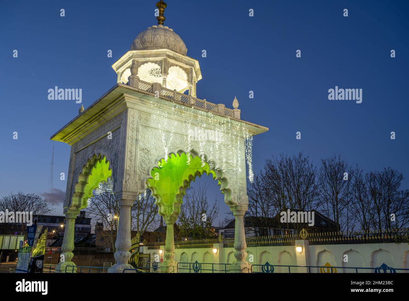 The entrance gate to the Sikh temple Siri Guru Nanak Darbar Gurdwara Gravesend Kent at night Stock Photo