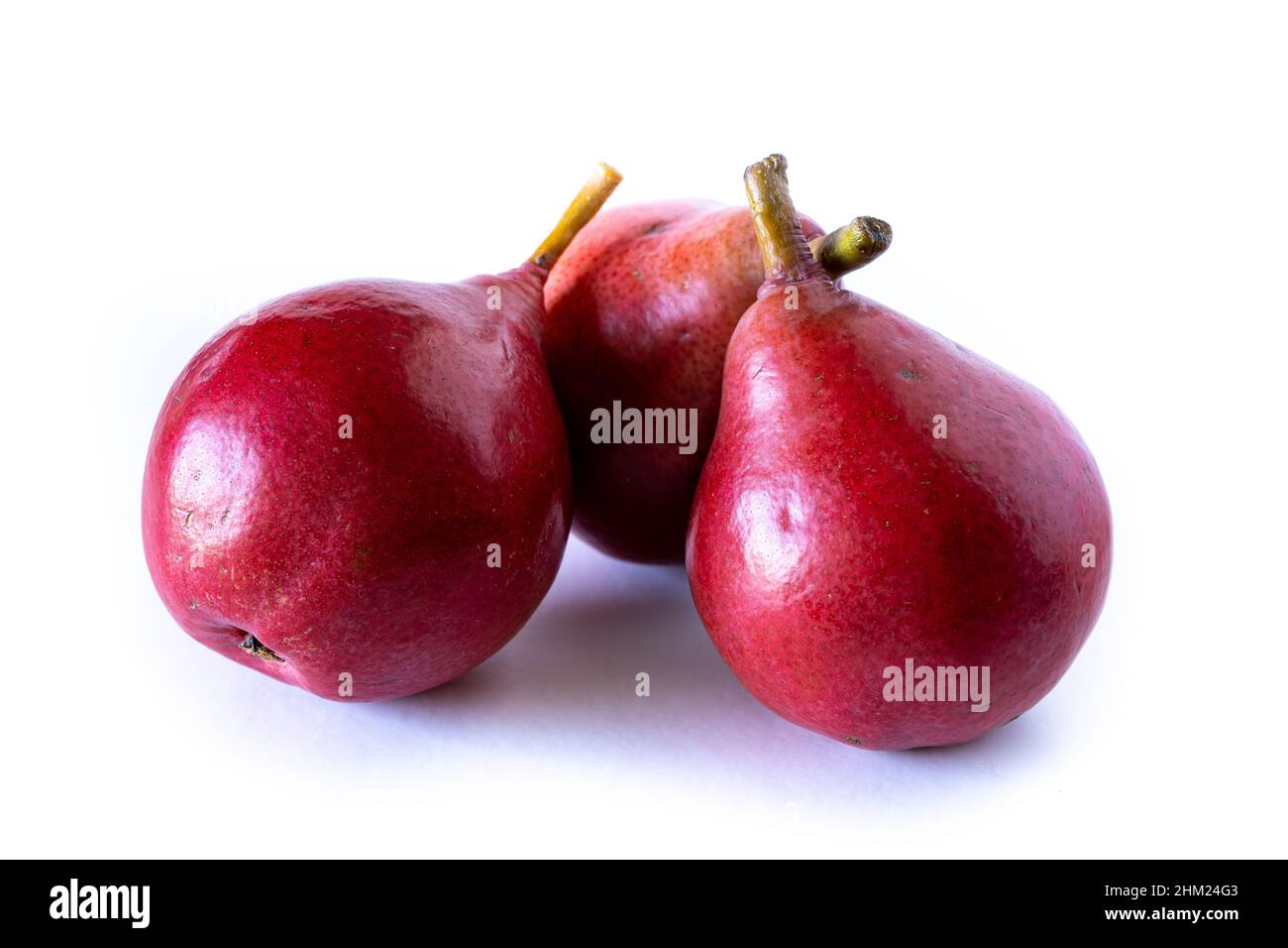 Three delicious red or red battler pears isolated on white background. Organic and natural products, healthy and wholesome food. Stock Photo