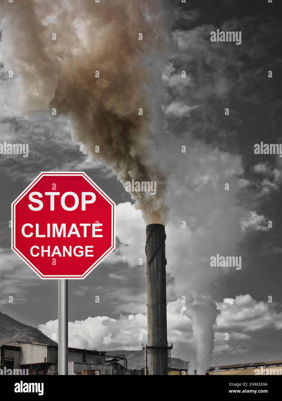 Tully sugar mill in Queensland spewing smoke and pollution into the air and stop climate change sign Stock Photo