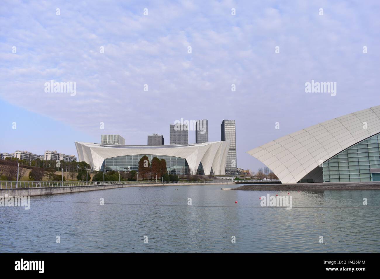 Beautiful exterior view of the Shanghai Oriental Sports Center with skyscrapers near the seaside Stock Photo