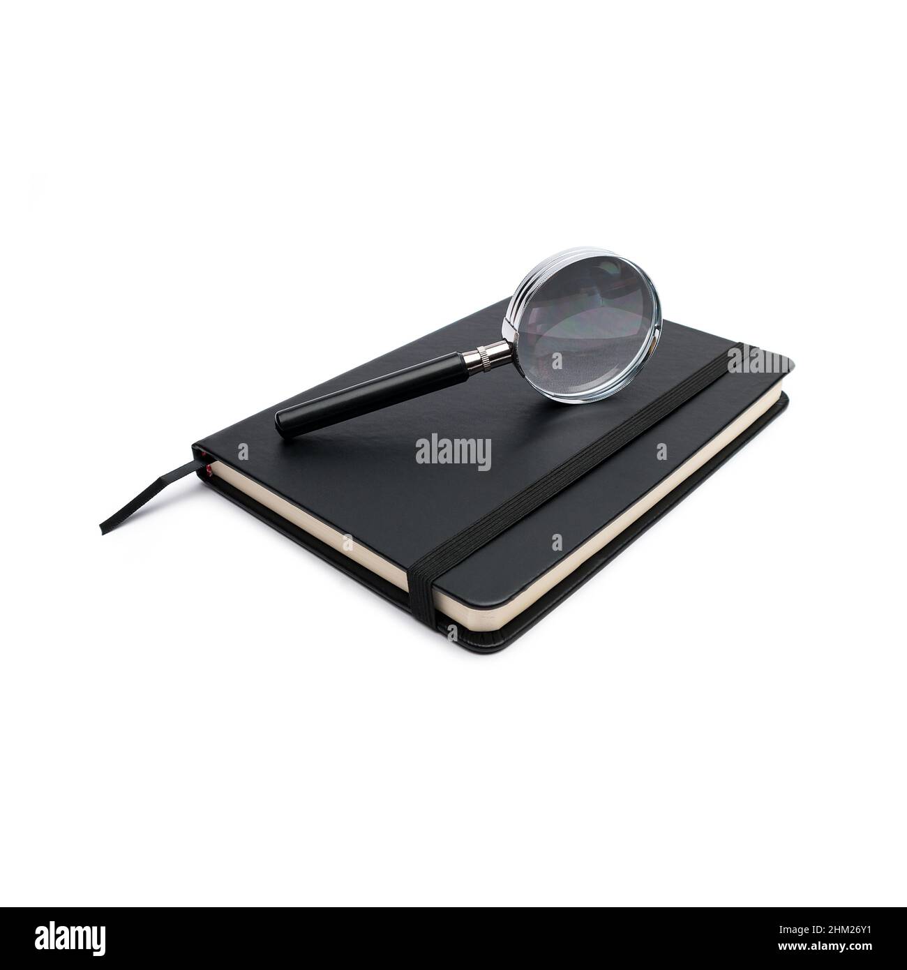 closed black notebook with magnifying glass on white Stock Photo