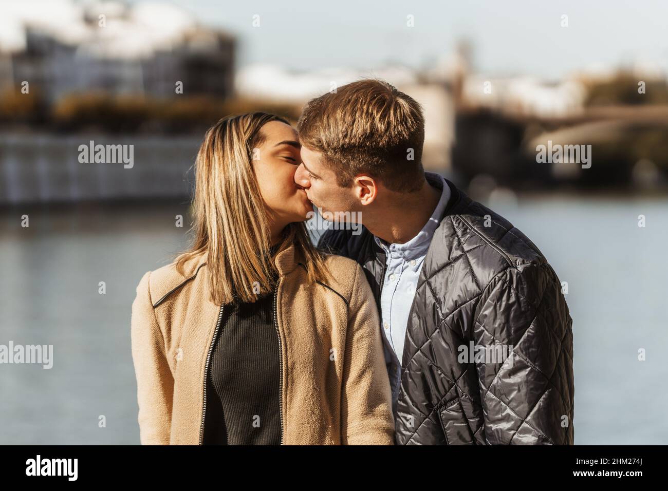 two boyfriends kissing on a river bank Stock Photo