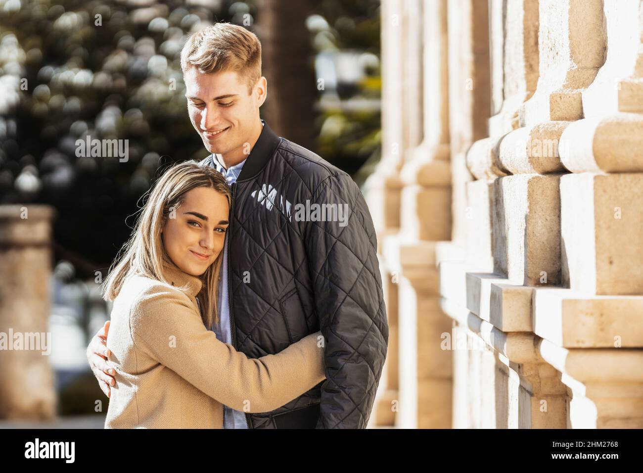 a young woman embraces her boyfriend in an affectionate way Stock Photo