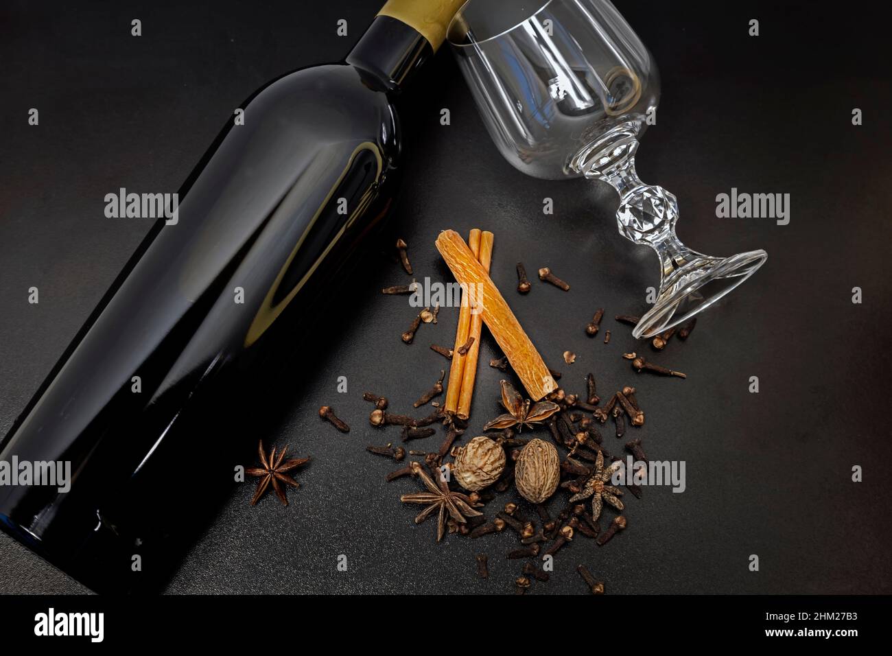 Mulled wine ingredients on a black background. Bottle of red wine