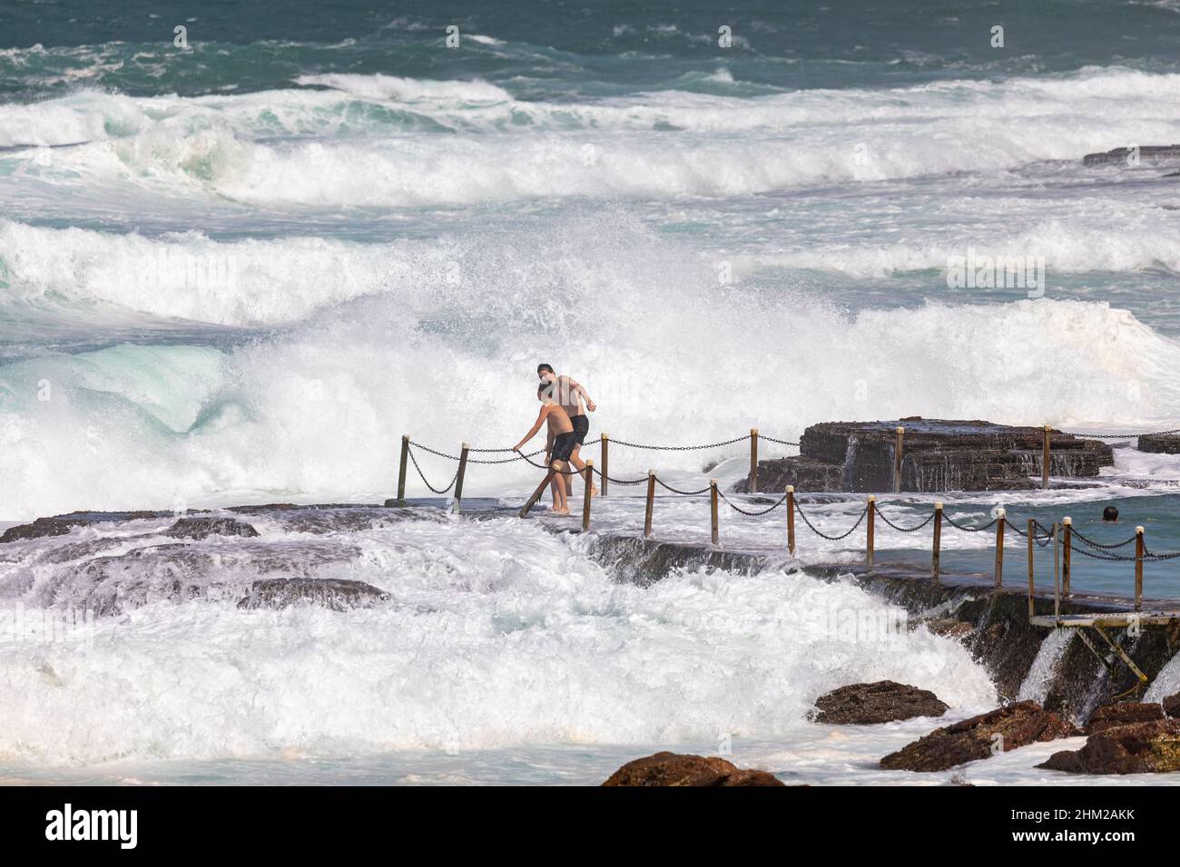 Two australian teenage boys playing and having fun in the large surf at Avalon Beach, NSW,Sydney,Australia Stock Photo