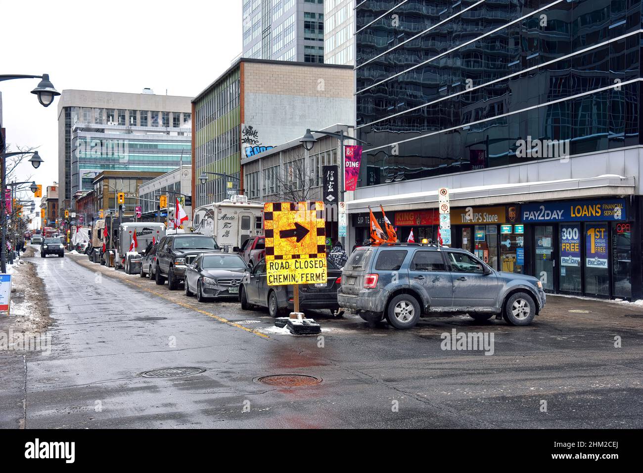 Ottawa, Canada – February 6, 2022: Bank Street in downtown Ottawa blocked with many trucks and vehicle as part of the trucker convoy protest. The protest has shutdown much of downtown Ottawa and caused a lot of grief for local residents and business. Stock Photo