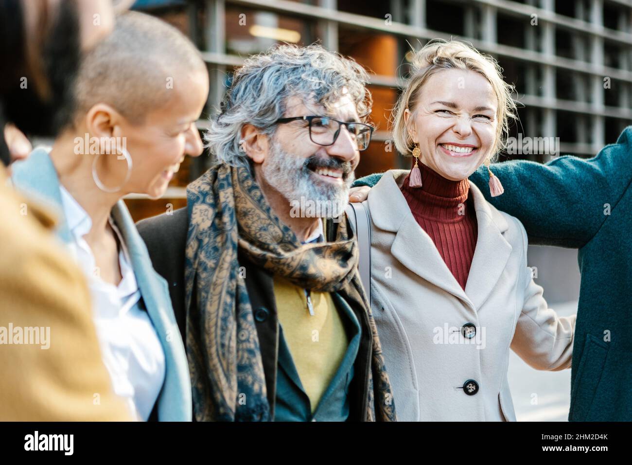 Happy multi age group of professional business people laughing together outdoors Stock Photo