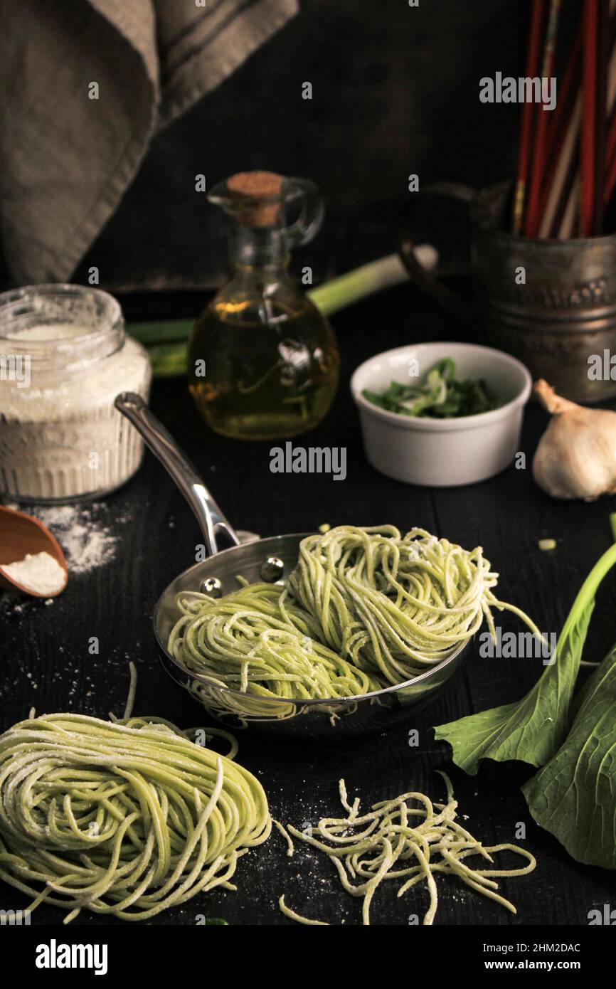 Homemade Raw Asian Green Vegetable Noodle in the Making. Home Cooking Process in the Kitchen (Mie Sawi Sayur). Stock Photo