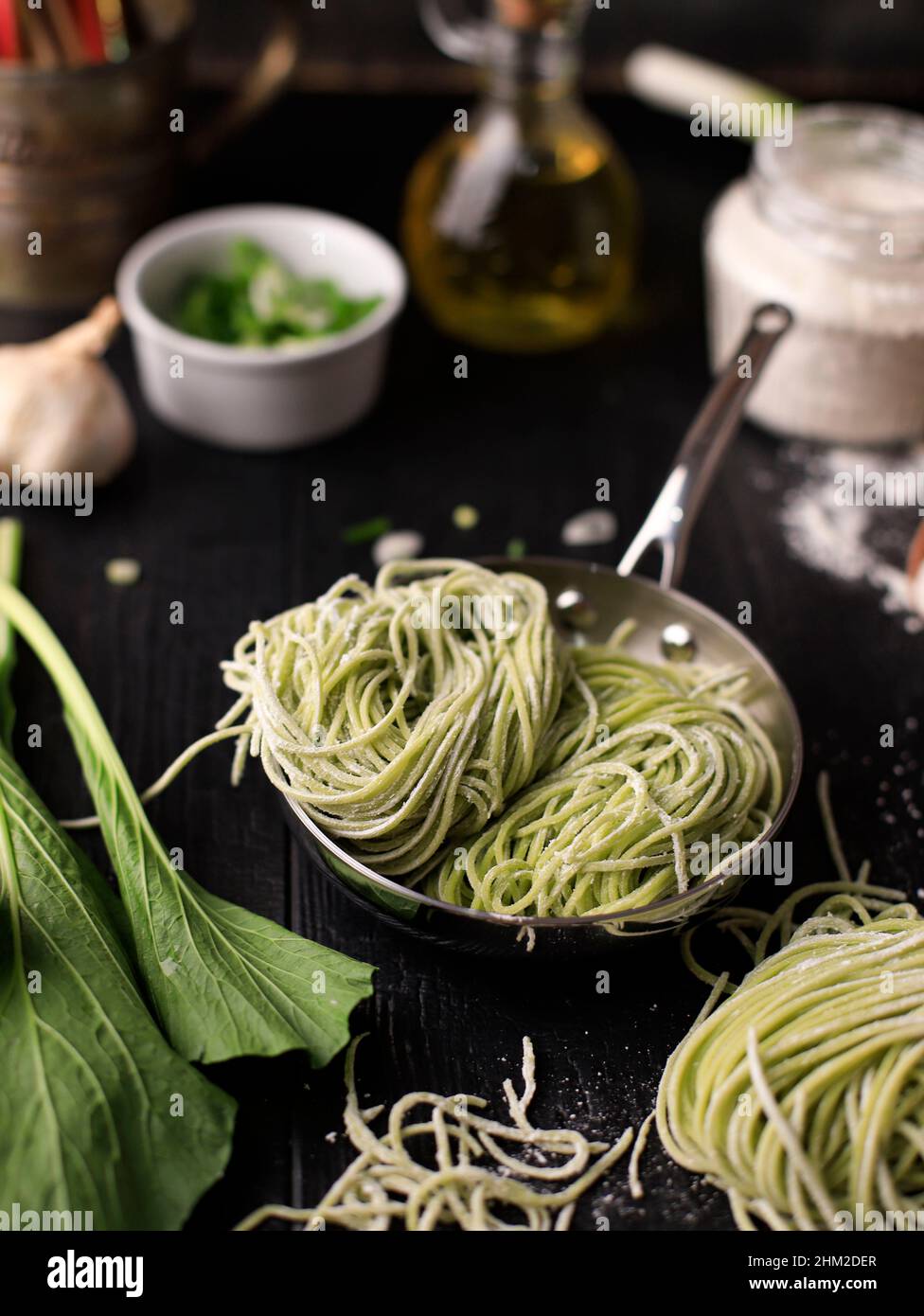 Homemade Raw Asian Green Vegetable Noodle in the Making. Home Cooking Process in the Kitchen (Mie Sawi Sayur). Stock Photo