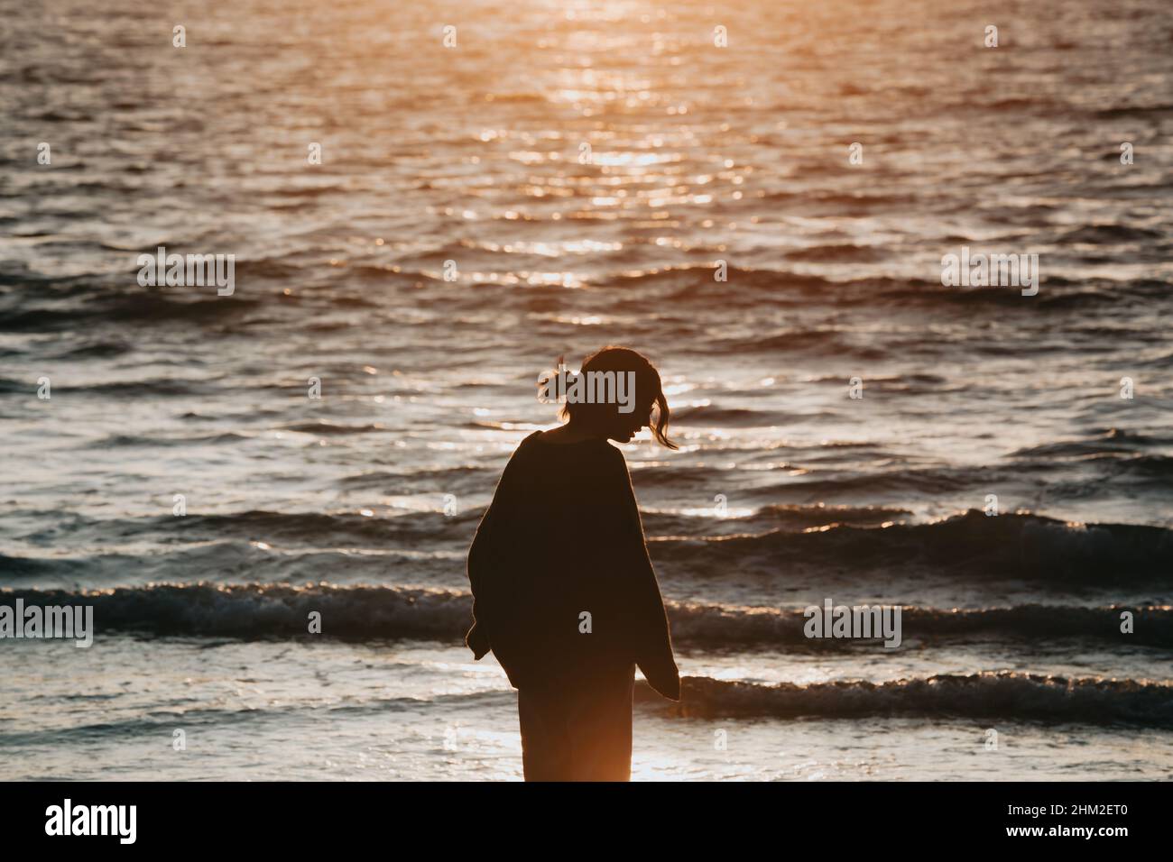 Woman watching sunset beach arms hi-res stock photography and images ...