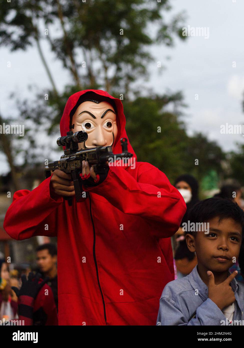 The people of Palembang city wear Red Jumpsuits and wear the Salvador Dali masks from the Money Heist Serial character to entertain visitors at one of the tourist attractions in the city of Palembang, South Sumatra. Behind the costumes and colors have meaning, the red jumpsuit was also chosen because red is a symbol for revolution and has been used by many resistance groups throughout history. Meanwhile, the meaning of the masks is in addition to maintaining their original identity. Salvador Dali masks are for purposes such as democracy, feminism and the environment. (Photo by Muhammad Shahab/ Stock Photo