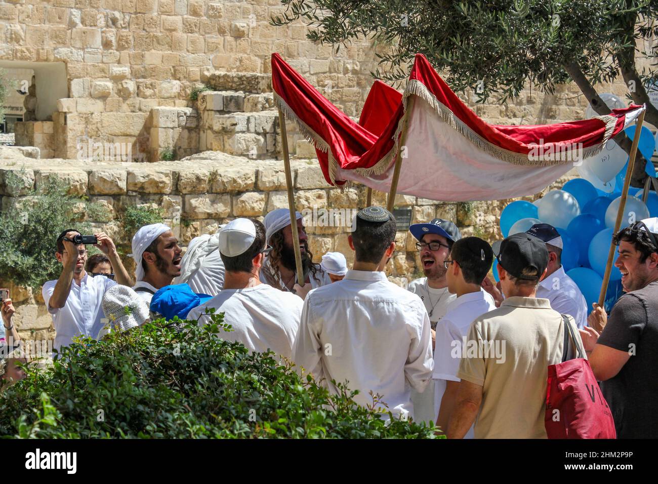 Participants in a Jewish Bar Mitzvah celebration carry a chuppah near the Walls of the Temple Mount in Jerusalem, Israel, 2016 Stock Photo