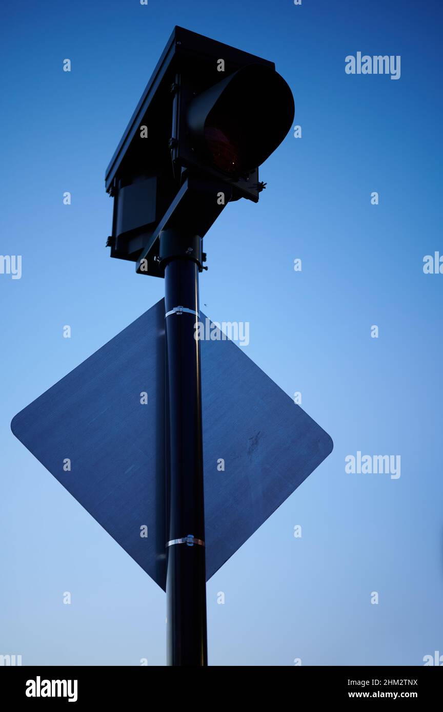 Low angle shot of a traffic light and road sign below on a metal pole ...
