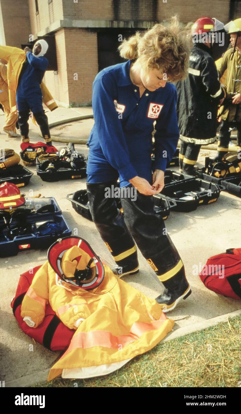 College Station Texas USA: Industrial firefighter puts on her turnout gear before training session at firefighting certification school. ©Bob Daemmrich Stock Photo