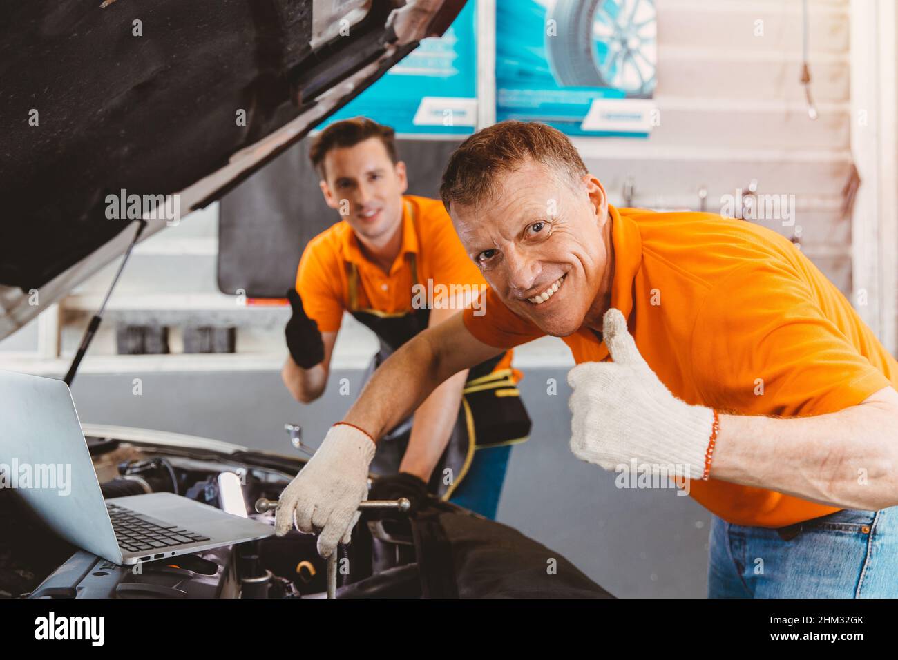 good car service staff happy mechanic teamwork for engine check Stock Photo