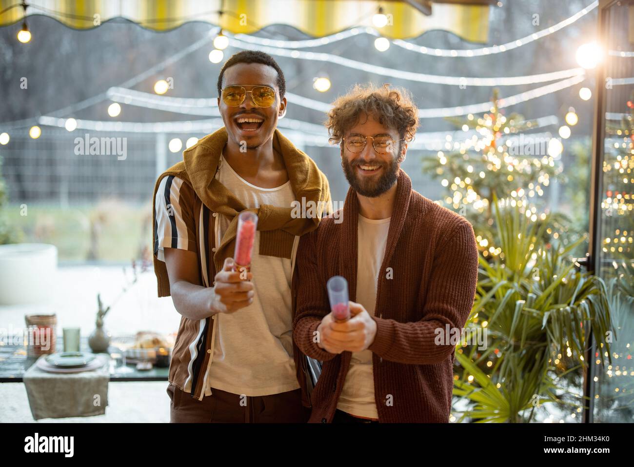 Two men celebrating winter holidays at backyard Stock Photo