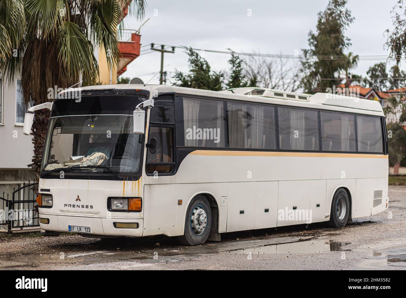 Side, Turkey -January 25, 2022: white  bus Mitsubishi Princess  is parked  on the street on a warm summer day against the  road and trees Stock Photo