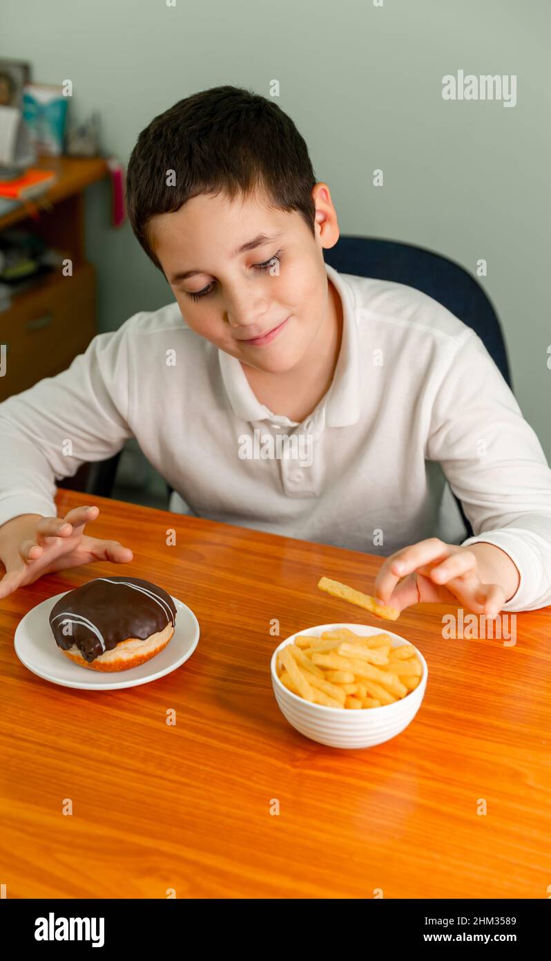 Kid eating chips having fun. Little child eats potato chips Stock Photo