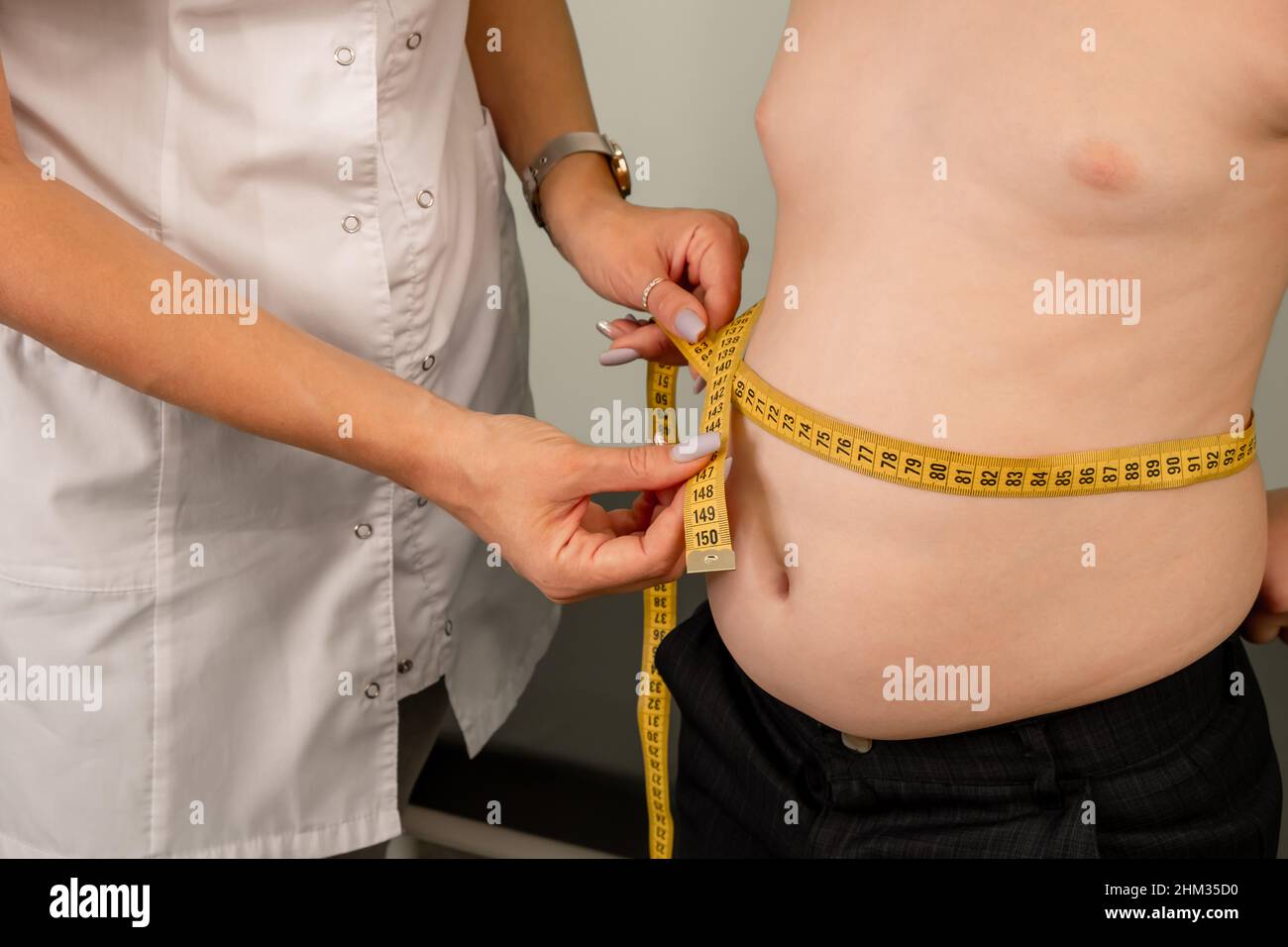 Overweight boy consulting with doctor. Doctor examining fat boy Stock Photo  - Alamy