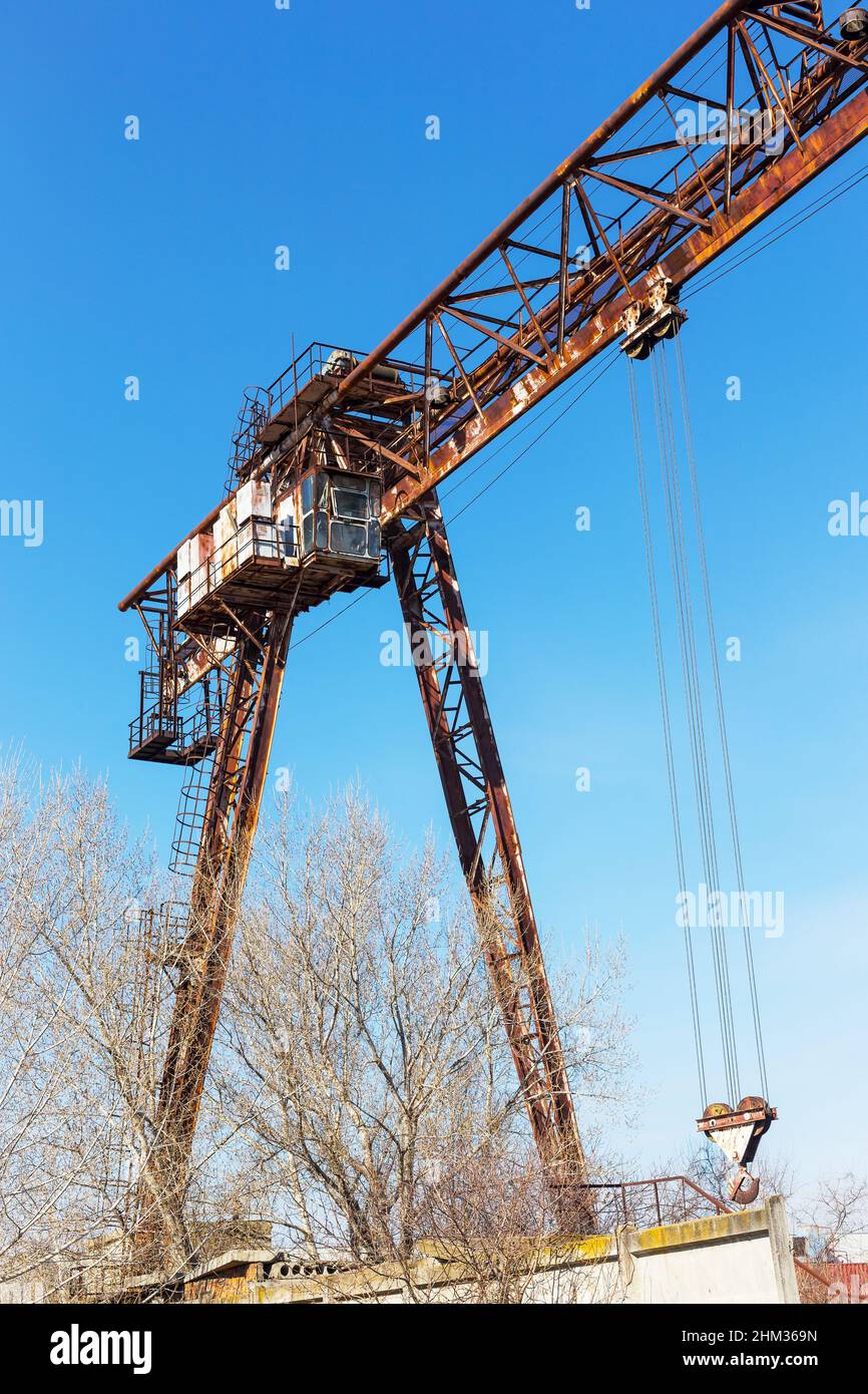 Old, rusty gantry crane on railroad, an abandoned concrete plant