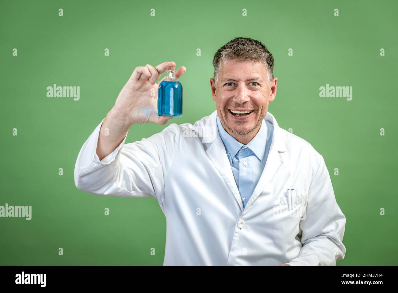 Scientist with white coat holding small flask with blue liquid and is ...