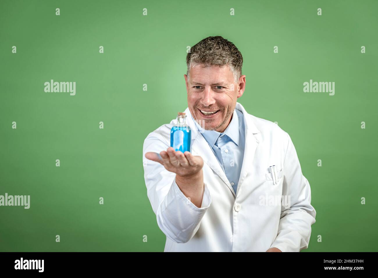 Scientist with white coat holding small flask with blue liquid and is ...