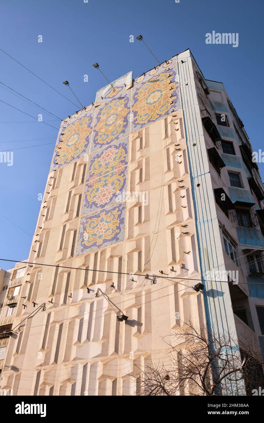 Soviet, Russian, USSR, CCCP era huge art mosaic tile mural shaped like a cross on the end of a large apartment building. In Tashkent, Uzbekistan. Stock Photo