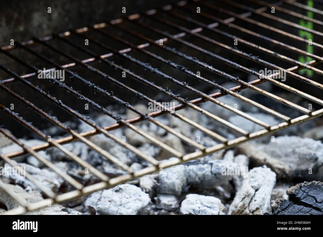 Glowing charcoal and grill grate are for cooking at temperature
