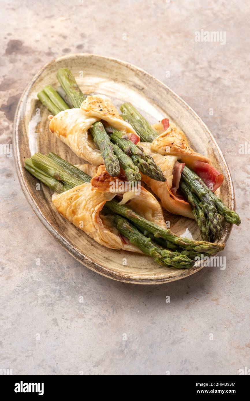 Baked green asparagus with bacon ham and cheese in puff pastry Stock