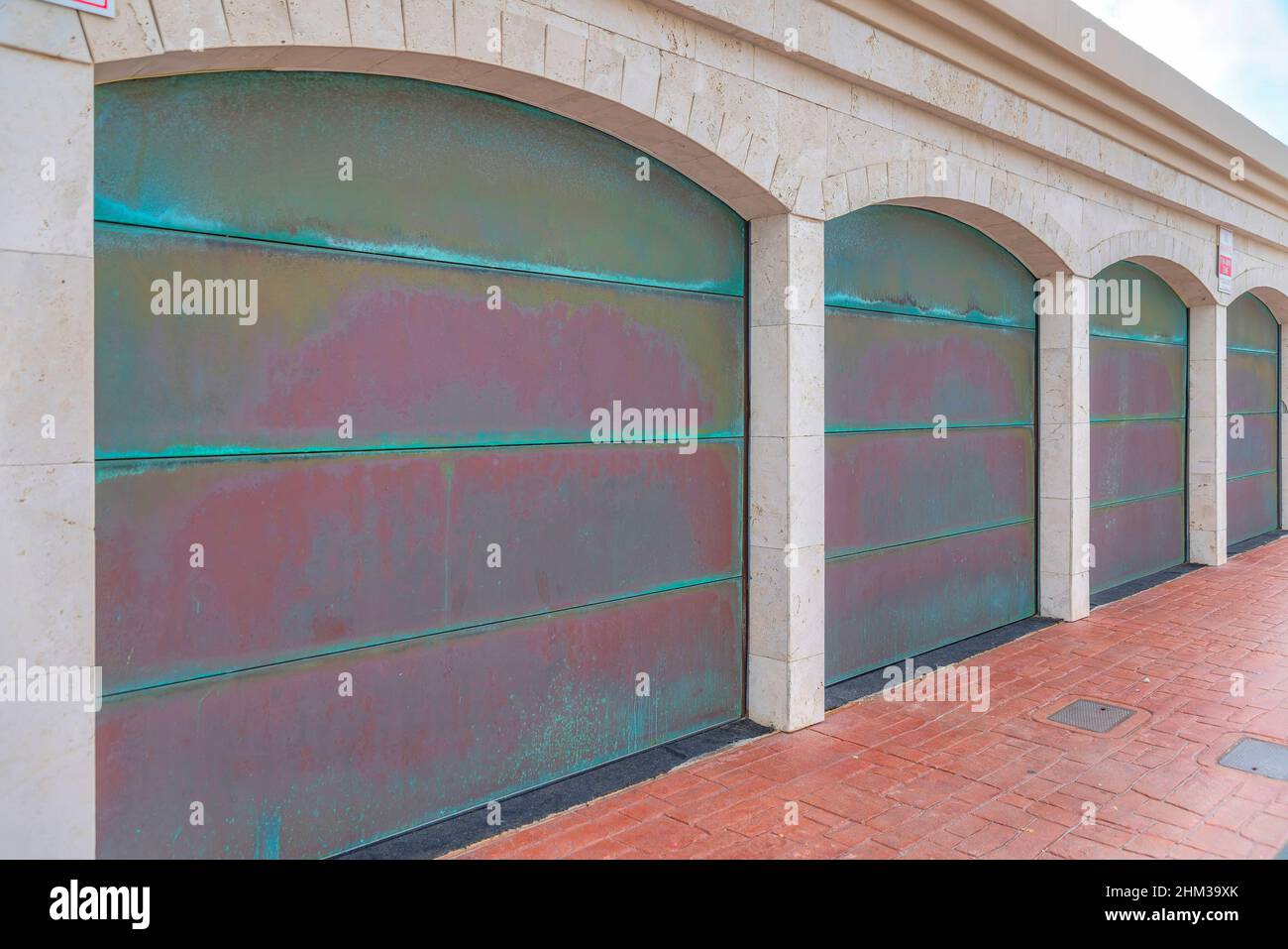 Old garage doors with fading colors and red bricks driveway at Carlsbad, San Diego, California Stock Photo