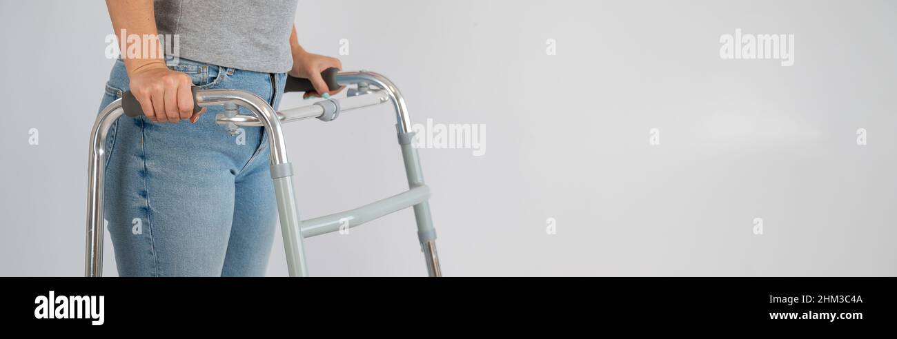 A woman is walking with a walker on a white background Stock Photo - Alamy