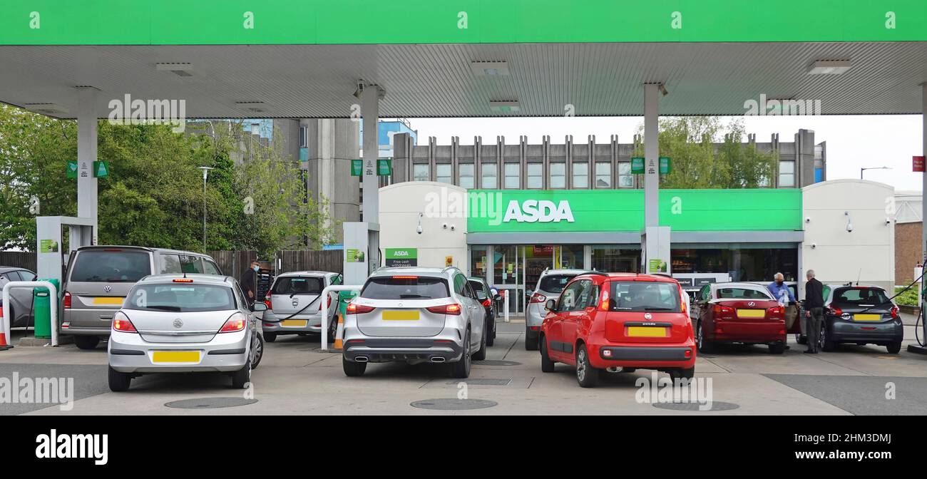Asda supermarket sign at busy petrol station with car drivers waiting & filling up at pumps with fuel in Rugby town centre Warwickshire England UK Stock Photo