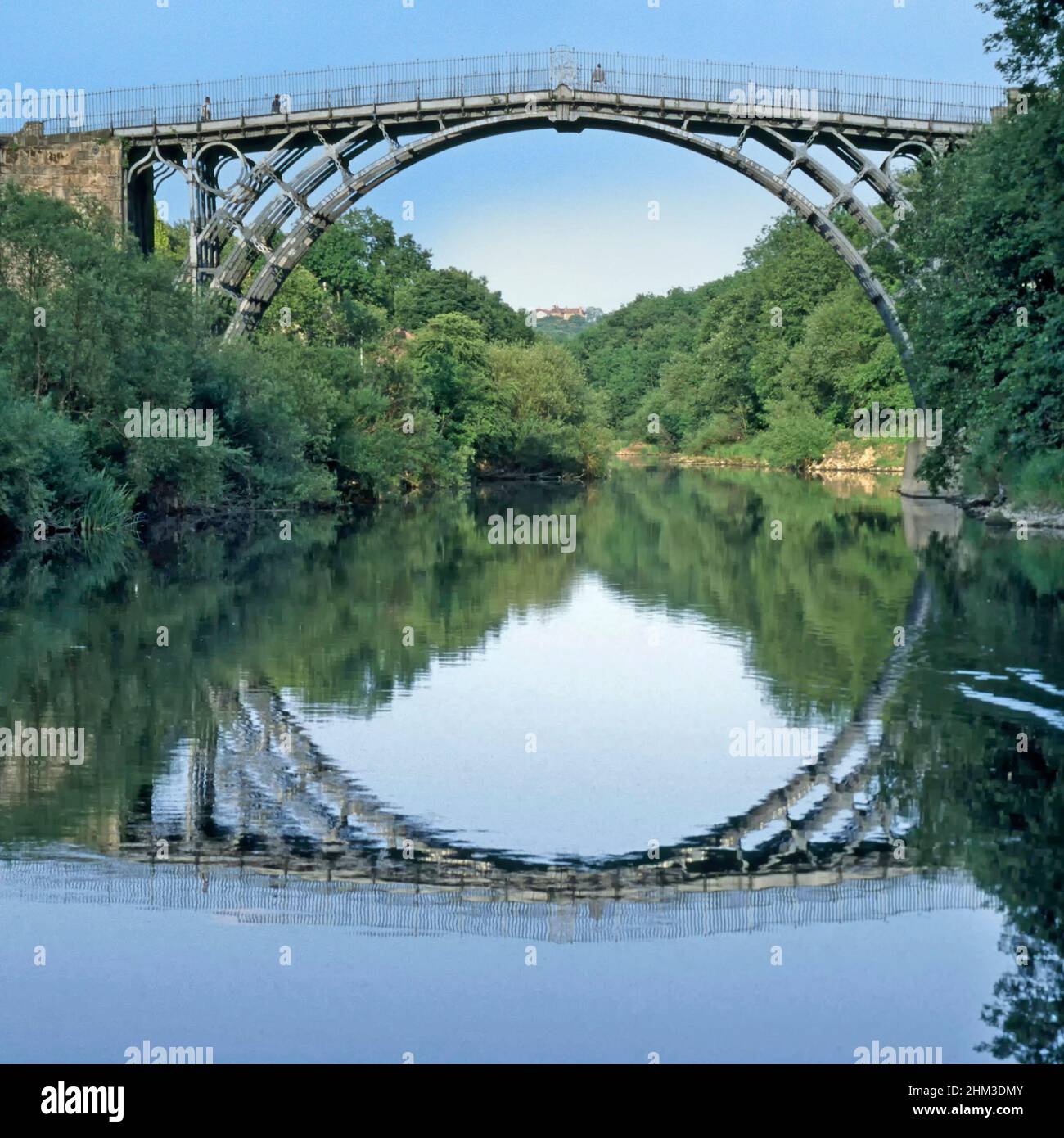 People on historical 1781 Iron Bridge & River Severn reflection by Thomas Pritchard first cast iron bridge at village of Ironbridge Shropshire England Stock Photo