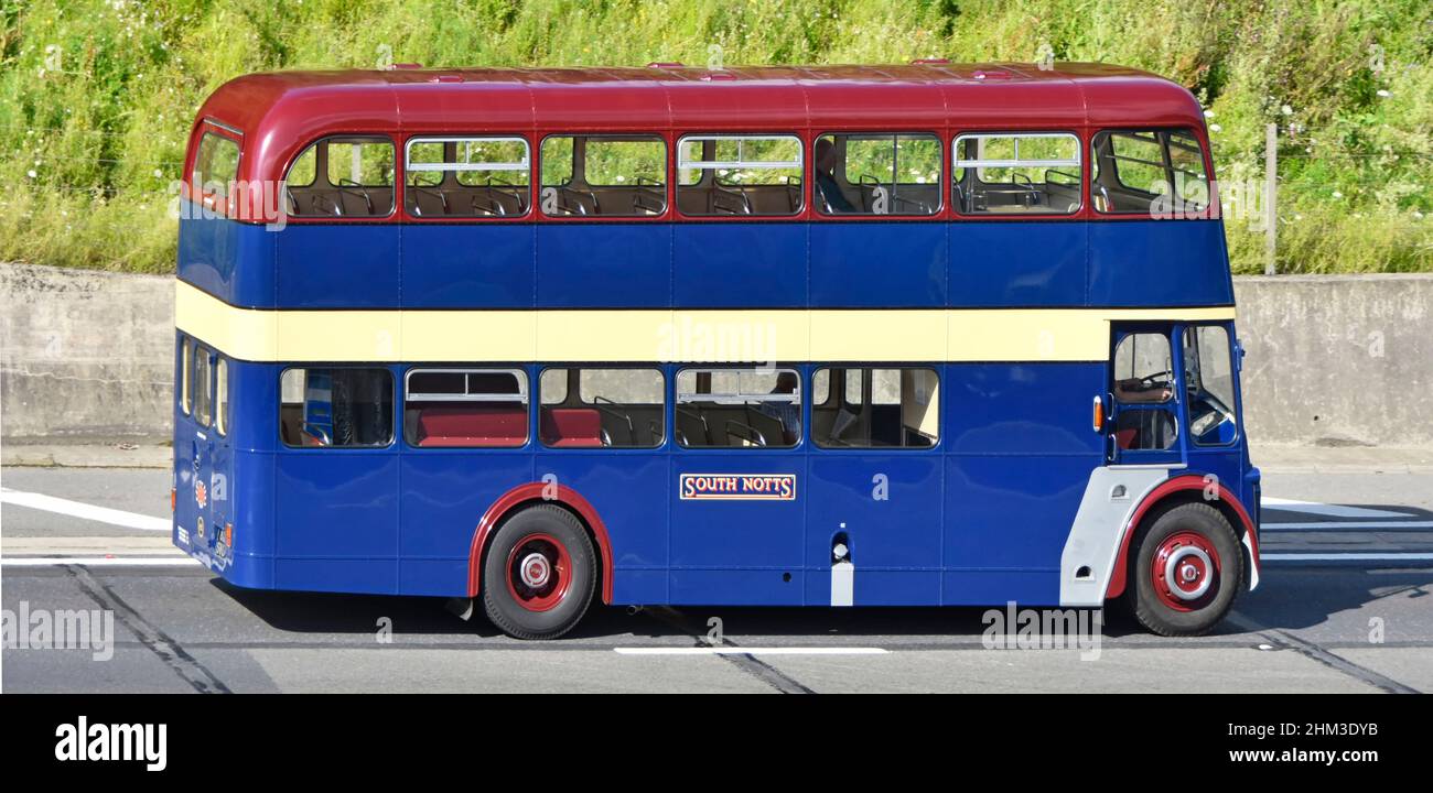South Notts Bus company side view, historical old double decker bus with two passengers and driver driving along on UK motorway road in Essex England Stock Photo