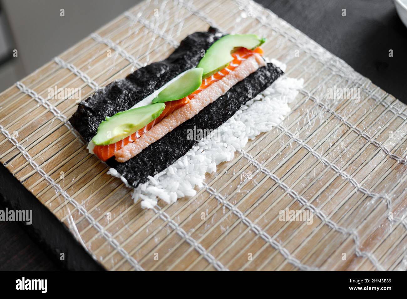 https://c8.alamy.com/comp/2HM3E89/ingredients-of-sushi-roll-ready-for-wrapping-on-the-bamboo-mat-2HM3E89.jpg