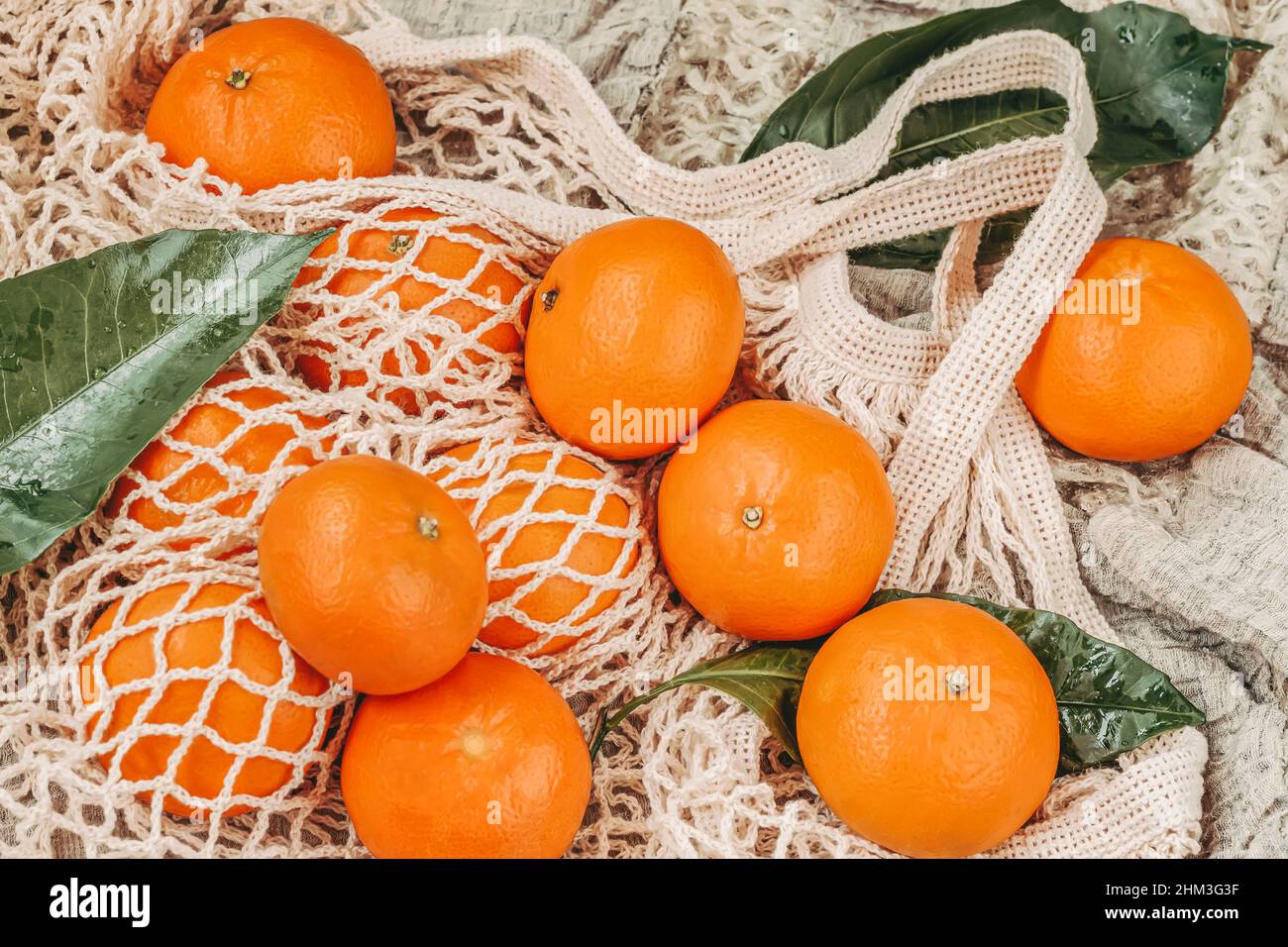 Fresh citrus fruits tangerines, oranges close-up on cotton mesh bag, rustic  style Stock Photo - Alamy