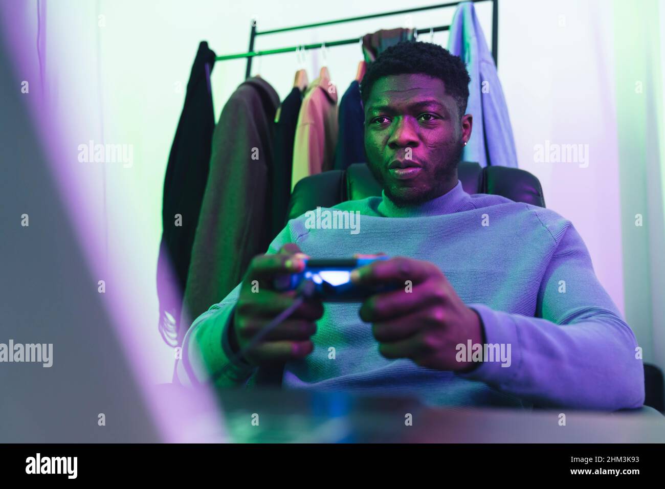 Focused afroamerican man playing video game joystic - medium shot. High quality photo Stock Photo