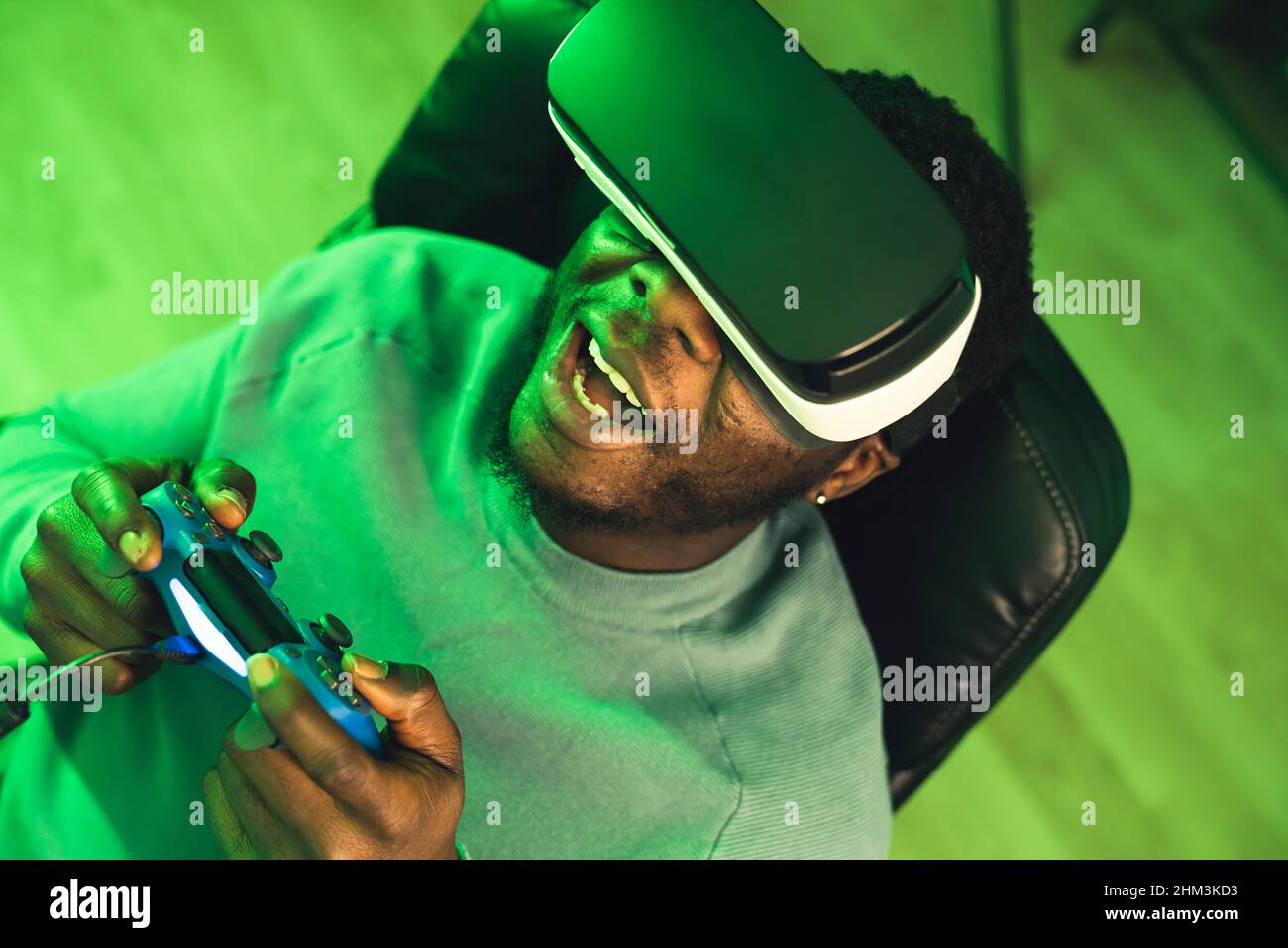 Happy black man playing VR headset blue game pad - portrait. High quality photo Stock Photo