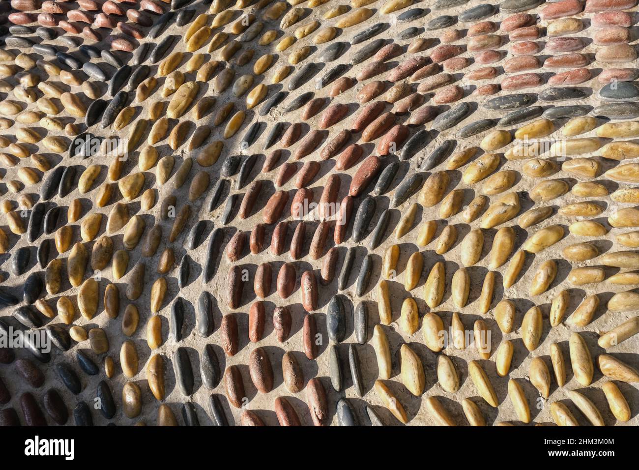 Fragment of reflexology cobblestones pathway for foot massage . Mosaic circle pattern from convex rounded pebble stones  Stock Photo
