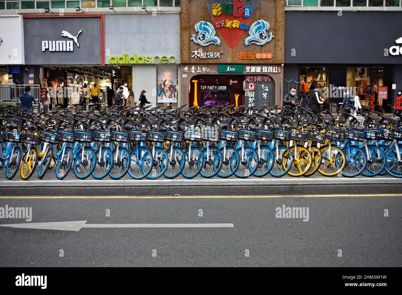 Shared bikes in a neat row filling the sidewalk in Shenzhen, China Stock Photo