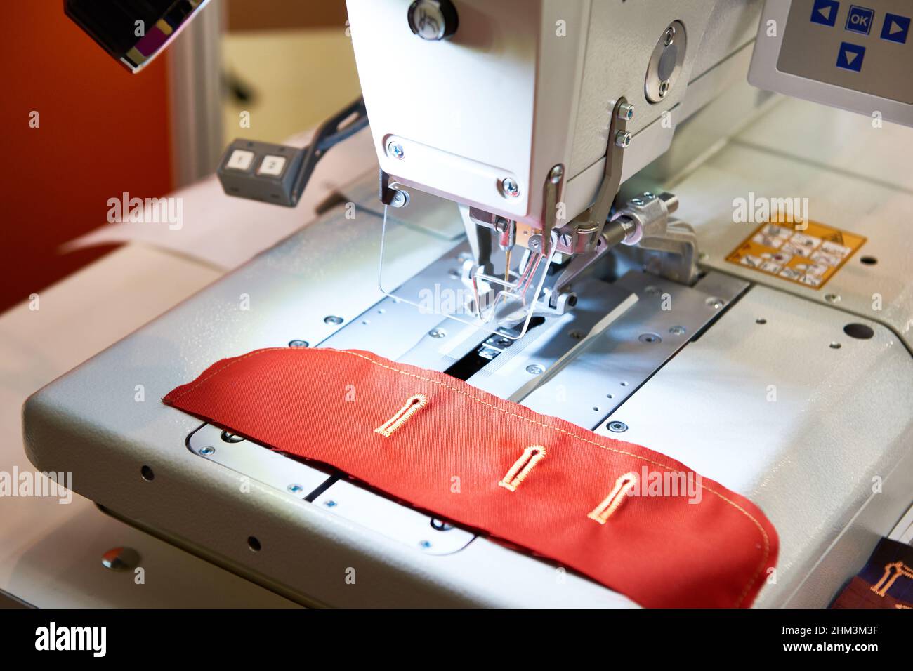 Sewing machine with red cloth button holes Stock Photo Alamy