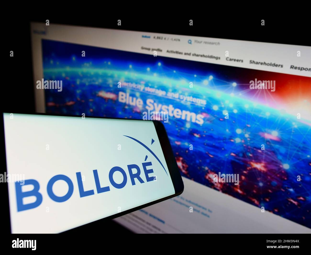 Smartphone with logo of French conglomerate company Bollore SE on screen in front of business website. Focus on right of phone display. Stock Photo