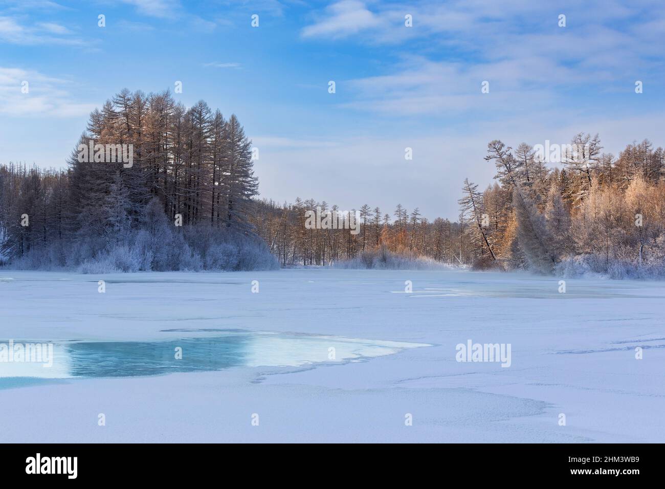 Winter landscape in the morning on the river with turquoise ice. Mouth of the Berkakit River in South Yakutia, Russia Stock Photo